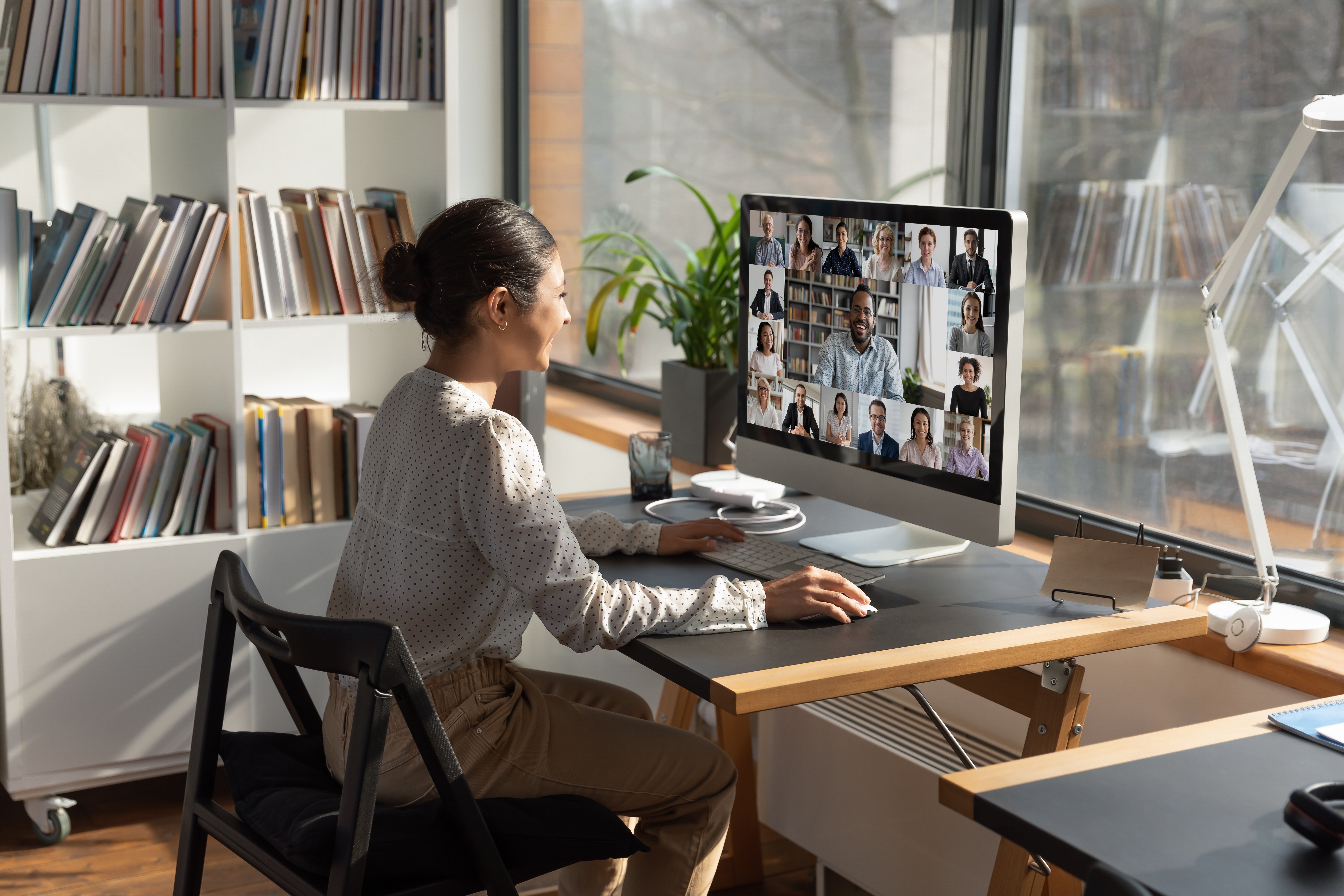 rear-view-indian-businesswoman-involved-internet-meeting-with-colleagues-group-video-call-diverse-businesspeople-employees-negotiating-discussing-project-strategy-using-webcam-computer